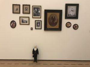 Dr. John Langdon-Down steht (als Aktion-Figur) vor den Familien Fotos in Raum 4 der TOUCHDOWN Ausstellung in Bern